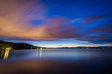 Long exposure of clouds moving over Lake Winnipesaukee at night,