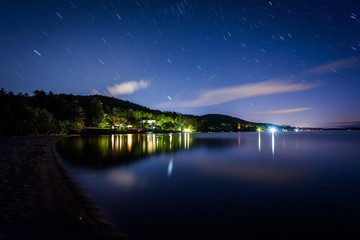 Long exposure of stars moving over Lake Winnipesaukee at night,