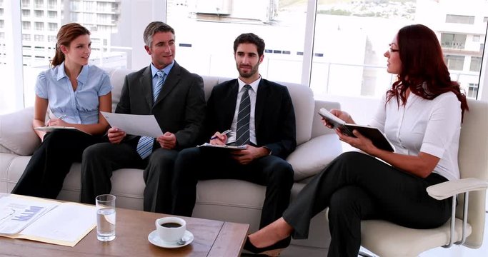 Business team sitting on couch having a meeting in the office