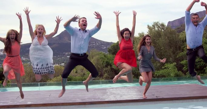 Group of friends jumping in swimming pool in slow motion 