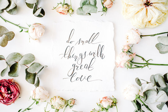 inspirational quote do small things with great love written in calligraphy style on paper with pink roses and eucalyptus branches on white background. flat lay, top view