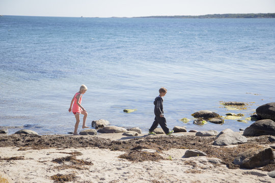 Sweden, Swedish West Coast, Halland, Kungsbackafjorden, Children (6-7, 10-11) walking on sea coast