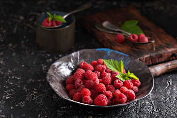 Fresh sweet raspberry in black bowl