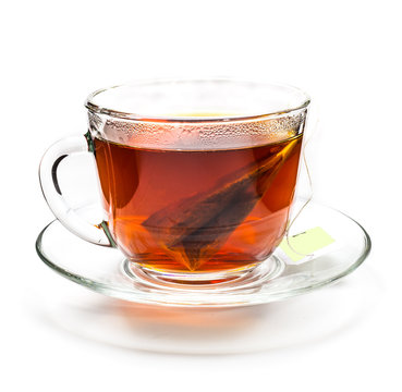 Transparent cup of tea with tea bag on white