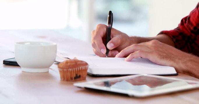 Hands of casual business man writing on paper 
