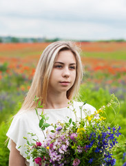 Beautiful blonde girl with wildflowers