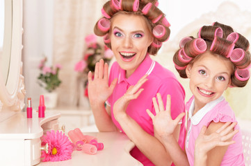 Obraz na płótnie Canvas Mother and daughter in hair curlers