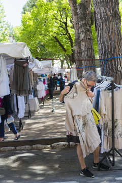 France, Alpes-Maritimes, Tourrettes sur Loup, Place de la Lib&eacute;ration, Woman trying on dress at flea market