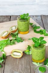 Ingredients for preparation of: kiwi, arugula, mint and two glasses smoothies