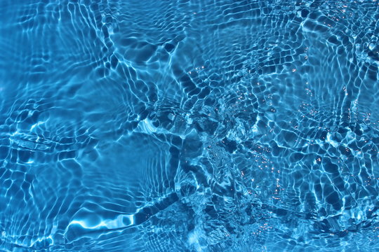Sun reflections in pool water from above