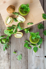 Ingredients for preparation of: kiwi, arugula, mint and two glasses smoothies