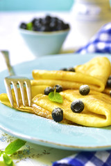 Thin pancakes with blueberry and honey.