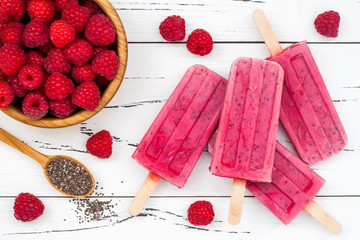 Homemade vegan raspberry coconut milk popsicles - ice pops - paletas with chia seeds on rustic...