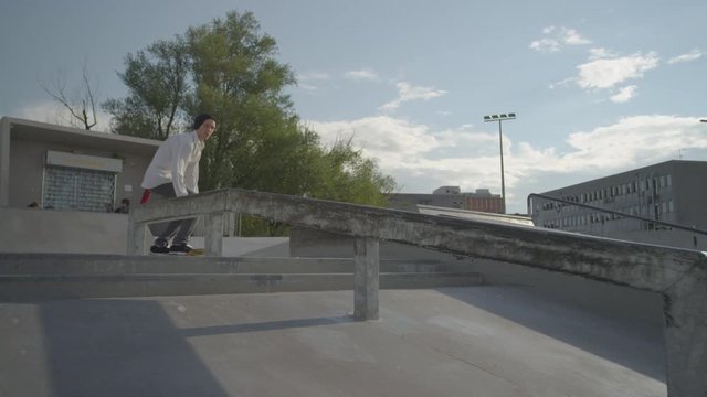SLOW MOTION: Skateboarder boardslide on a rail
