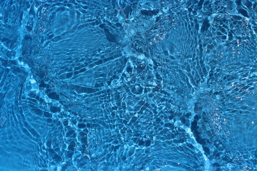 Sun reflections in pool water from above