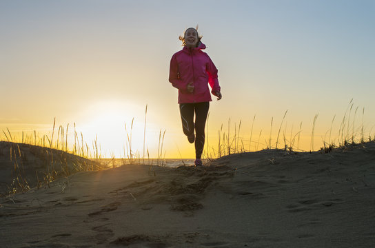 Finland, Pohjanmaa, Pietarsaari, Faboda, Young woman jogging on beach at sunset
