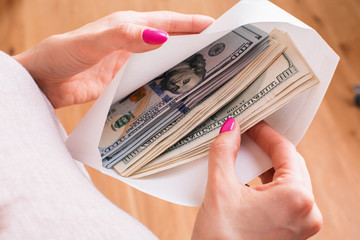 Female holding envelope with cash