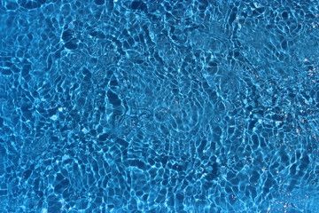 Sun reflections in pool water from above