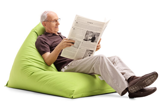 Senior reading the news seated on beanbag