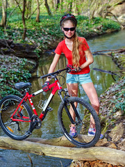 Fototapeta na wymiar Bikes cycling girl. Girl rides bicycle. Girl cycling fording throught water . Cycling trip is good for health. Cyclist in helmet look at camera.