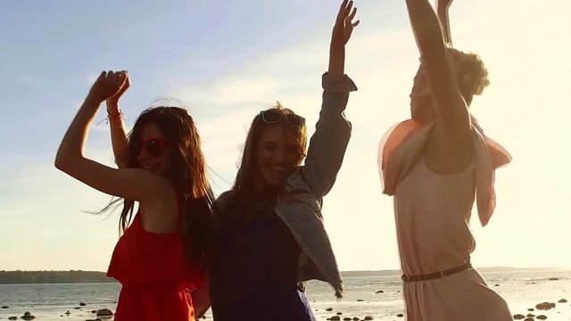 group of happy women or girls dancing on beach 35