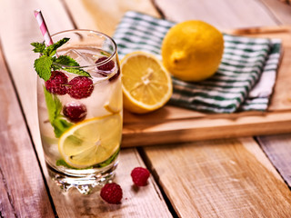 Alcohol cocktail. On wooden boards glass with raspberry alcohol cocktail and ice cubes. Drink number hundred nineteen cocktail raspberry mojito with lime and mint leaf. Country life. Light background.