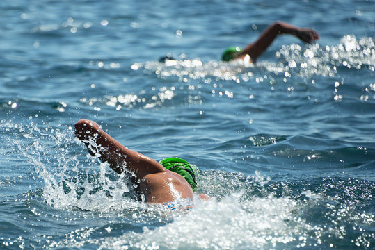 Two swimmers swam in the sea, view from behind