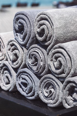 Stack of grey rolled towels in hotel near beach