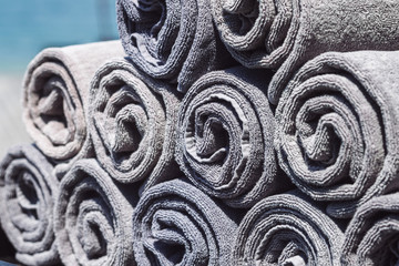 Stack of grey rolled towels in hotel near beach