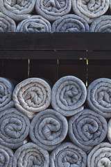 Stack of grey rolled towels in hotel near beach