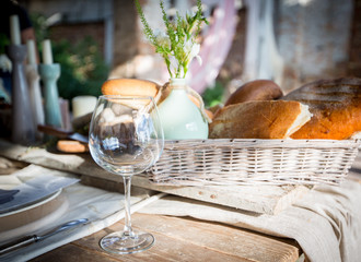 The table on which stands a vase of flowers and a basket of biscuits and bread and cheese
