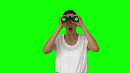Businesswoman looking with binoculars on green screen background - Powered by Adobe