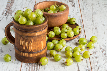  Gooseberries.   Freshly picked gooseberries in a wooden crockery on a light wooden table.