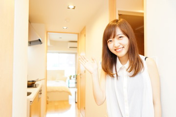 一人暮らしの部屋にお客さんを招き入れる日本人の若い女性