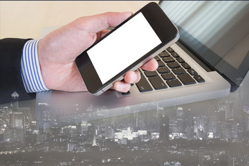 businessman hand on smat phone with cityscape background