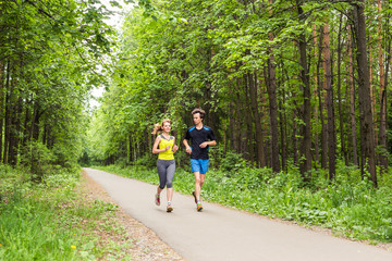 Obraz premium Young Couple Running In Wooded Forest Area - Fitness Healthy Lifestyle Concept
