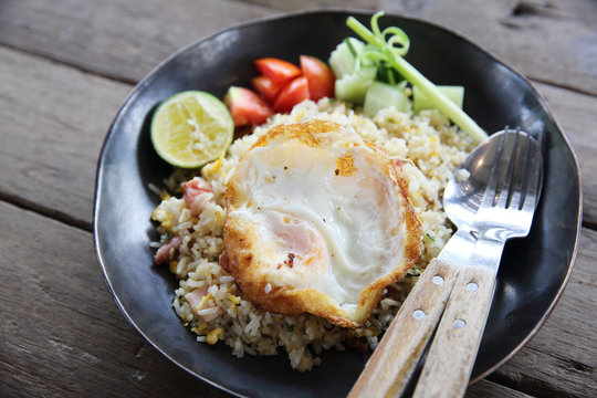 fried pork bacon rice with Poached egg on wood background Thai f
