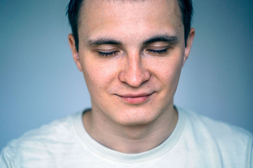 Fototapeta premium Closed eyes portrait of young man. Head and shoulders shot