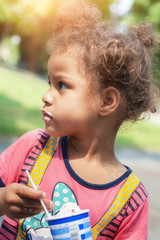 Cute little girl eating ice cream cone
