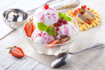 Ice Cream with Strawberry, Mint and waffles. Homemade product. On the wooden table.