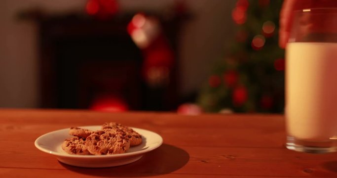 Hand leaving cookies and milk out for santa in high quality 4k format