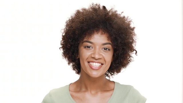 Surprised young beautiful african girl laughing over white background.