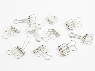 The silver binder clip (paper clip stationery).