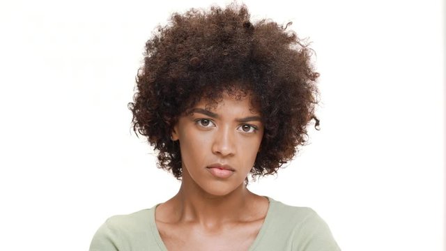Resentful young beautiful african girl over white background.