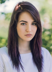 Outdoors portrait of beautiful young woman with dark hair.