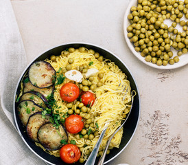 Spaghetti with green peas and fried tomatoes and eggplant