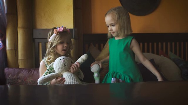 Two Cute Little Girls Are Playing In A Cafe