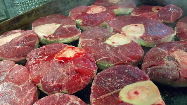 Frying osso buco veal meat steaks, on a frying board