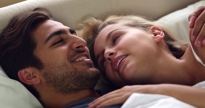 Cute couple talking in bed