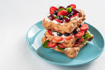 Pavlova cake with strawberry blueberry, cherry, mint
